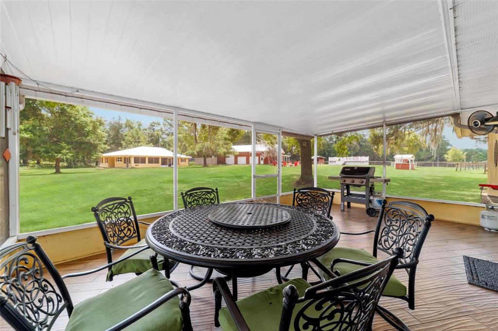 16520 Northwest 170th Street Williston, FL 32696 - Photo 65 of 98 a view of a patio with a table chairs and a yard