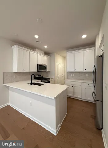 a kitchen with stainless steel appliances a stove a sink and a refrigerator