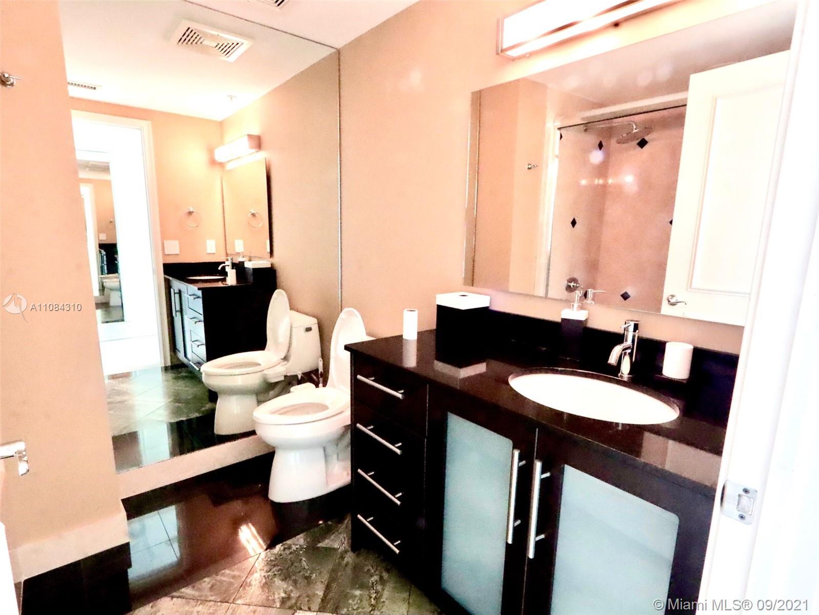 The Grove Coconut Grove, FL 33133 - Photo 24 of 31 a bathroom with a sink a toilet and a mirror