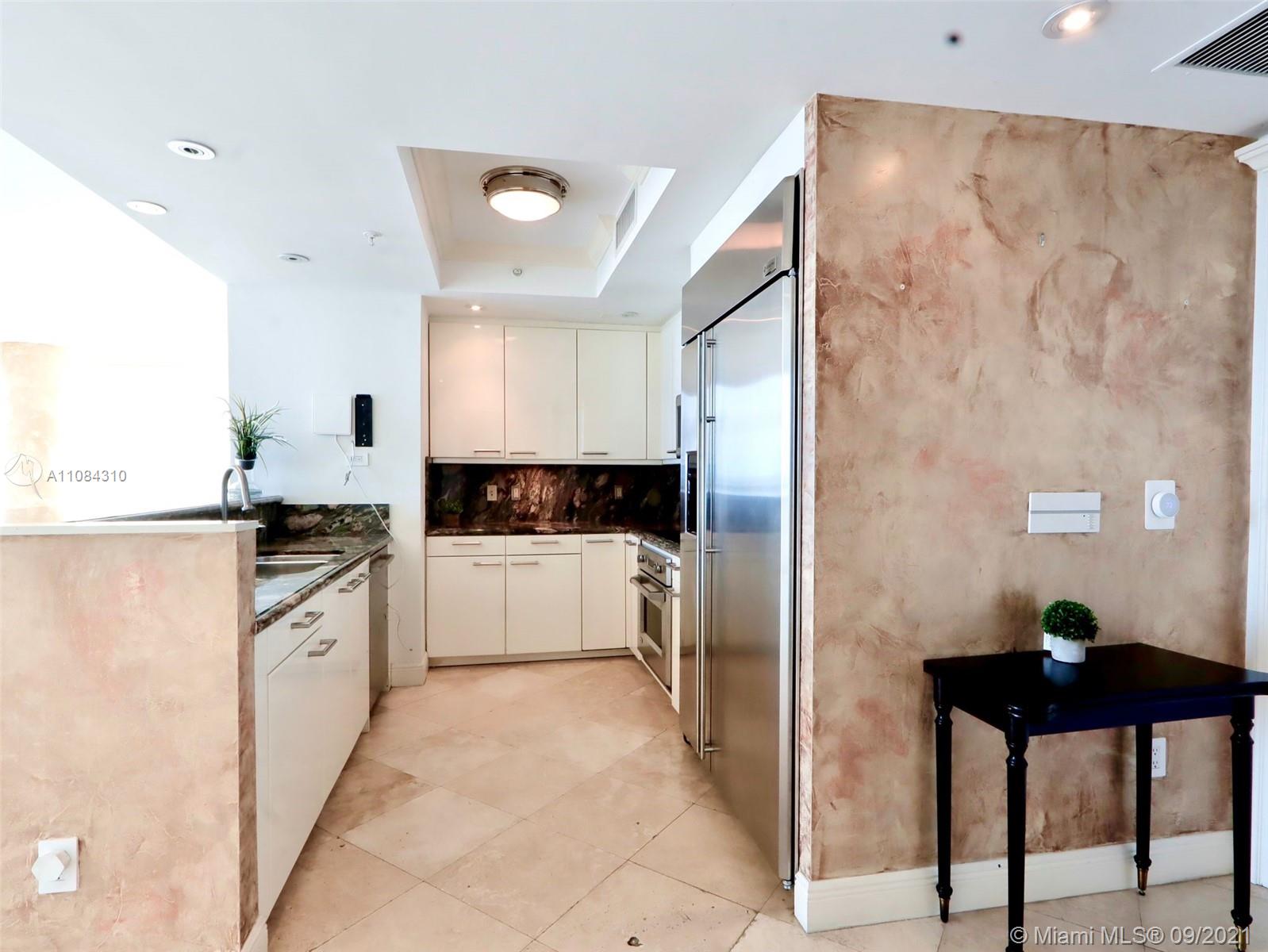 The Grove Coconut Grove, FL 33133 - Photo 28 of 31 a kitchen with a refrigerator and white cabinets