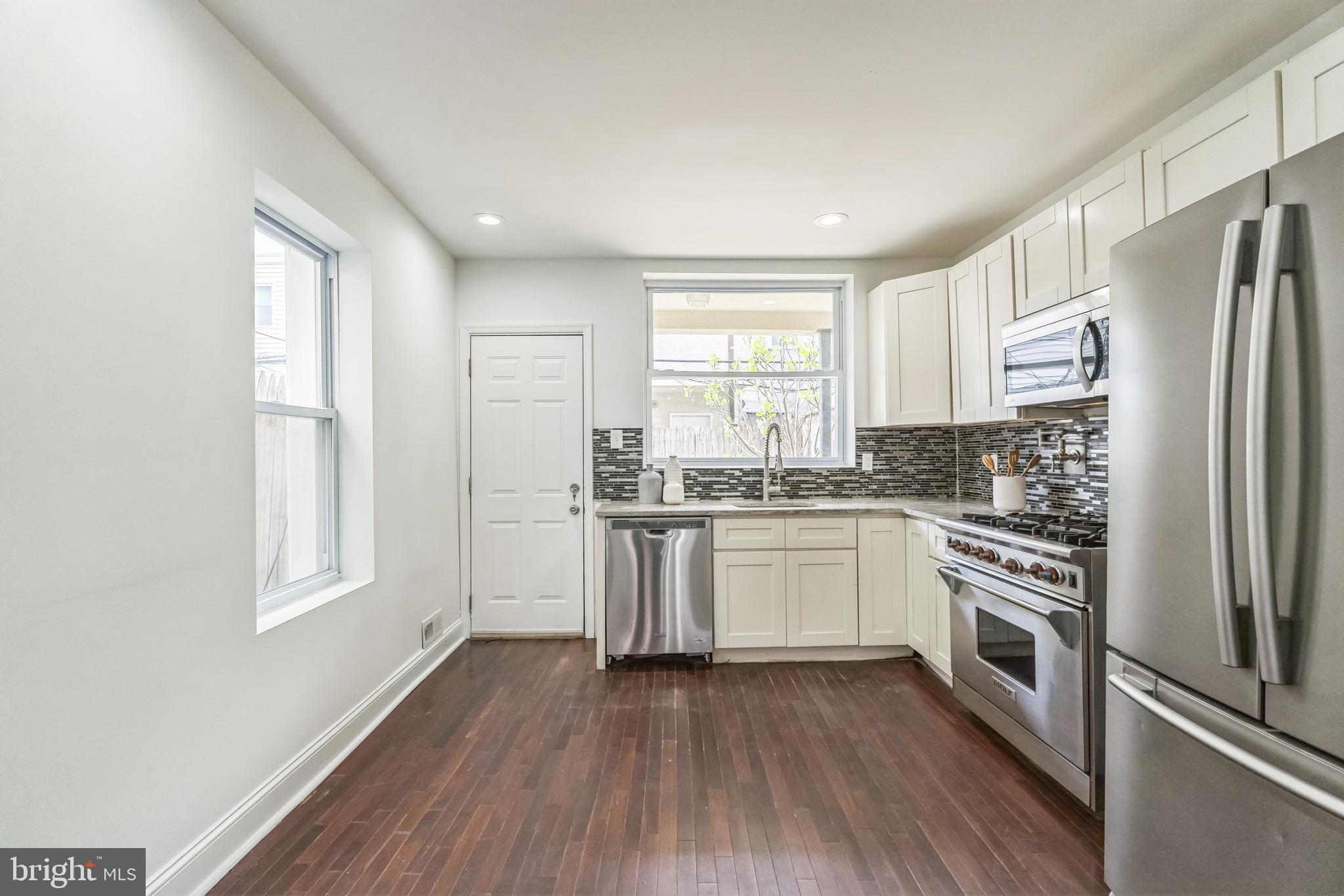 1816 Reed Street Philadelphia, PA 19146 - Photo 13 of 30 a kitchen with a refrigerator wooden floor and window