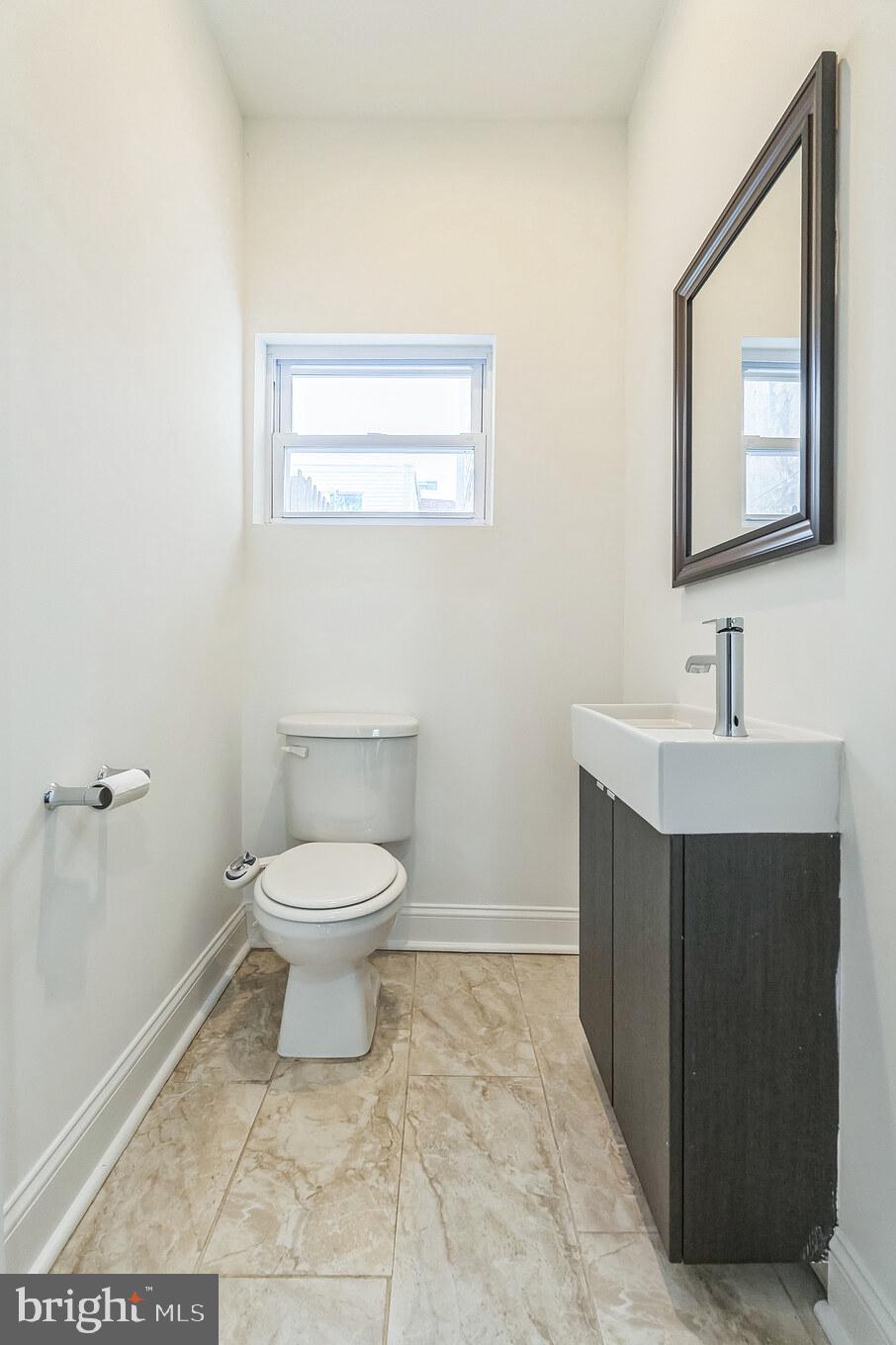 1816 Reed Street Philadelphia, PA 19146 - Photo 15 of 30 a bathroom with a toilet sink vanity and mirror