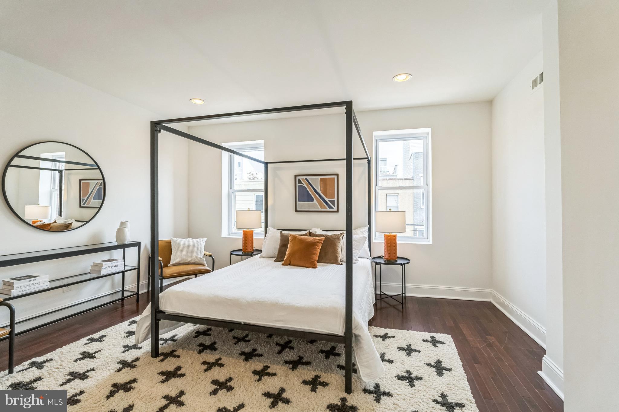 1816 Reed Street Philadelphia, PA 19146 - Photo 17 of 30 a bedroom with a bed a mirror and lamp on desk