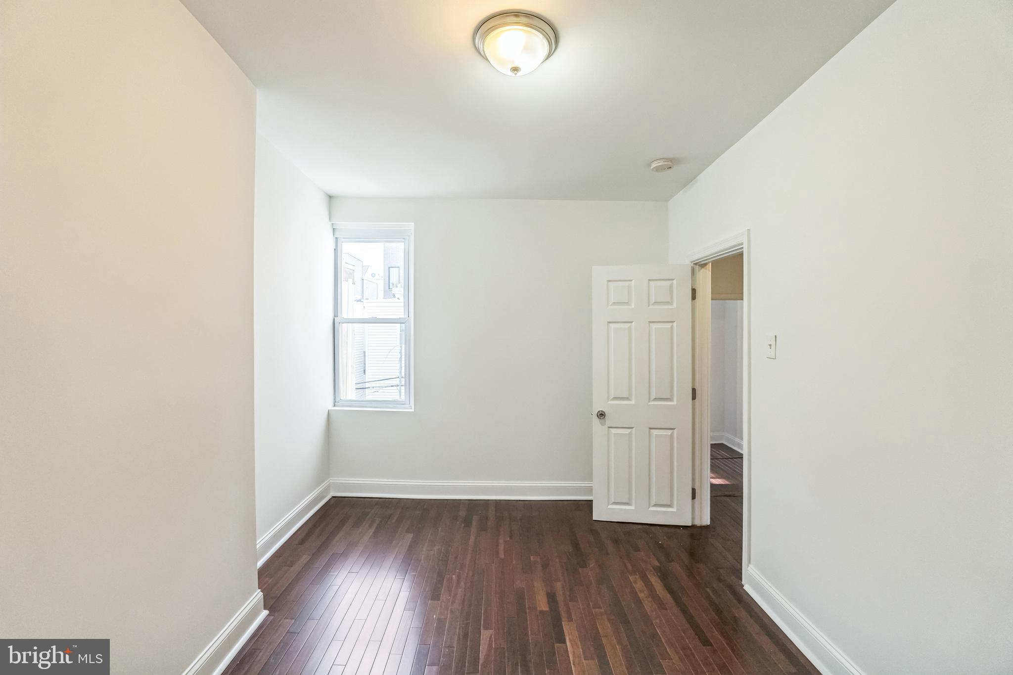 1816 Reed Street Philadelphia, PA 19146 - Photo 23 of 30 an empty room with wooden floor and windows