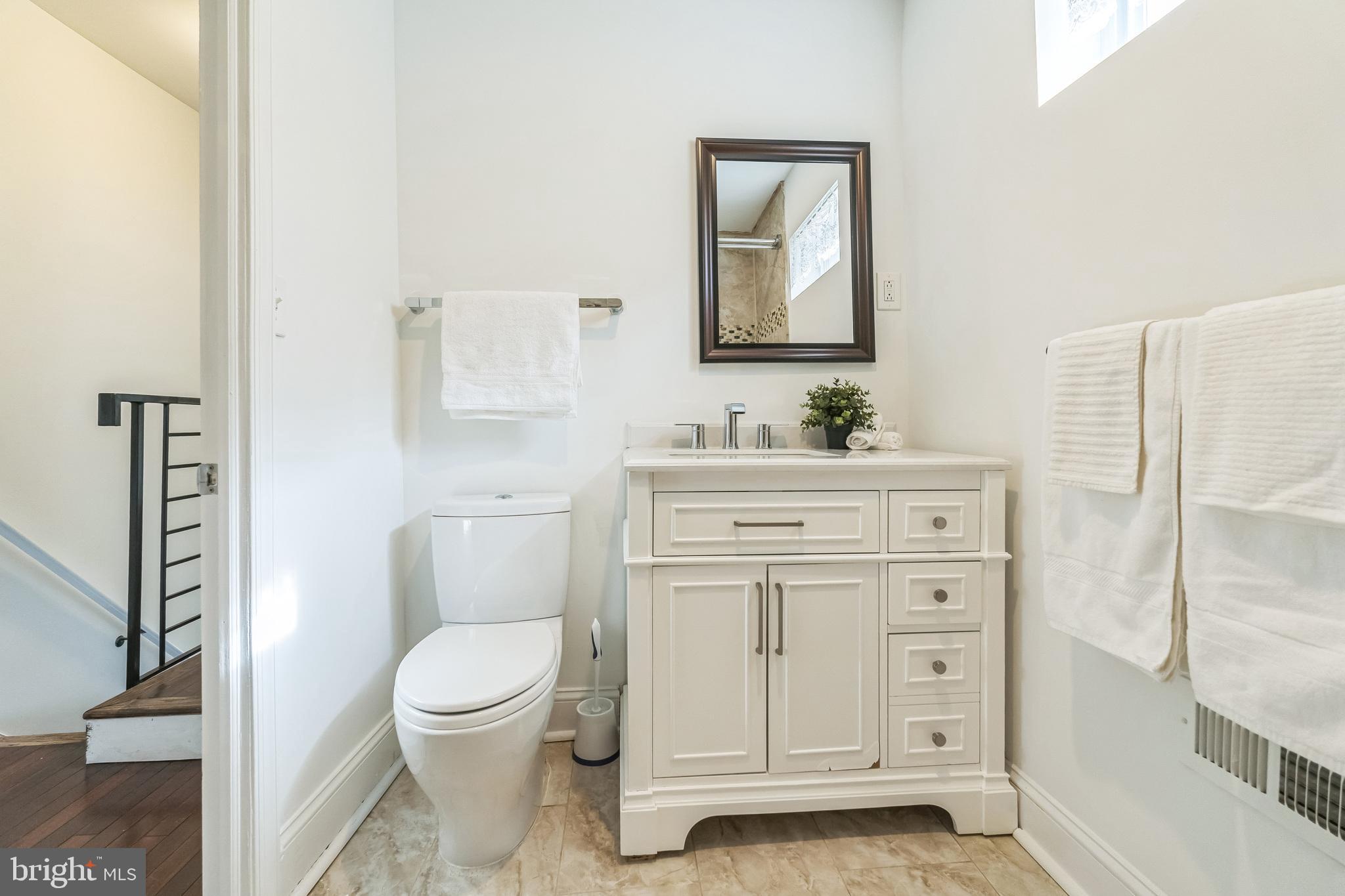 1816 Reed Street Philadelphia, PA 19146 - Photo 24 of 30 a bathroom with a toilet sink vanity and mirror