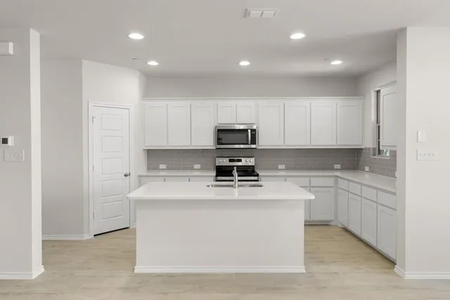 a kitchen with stainless steel appliances granite countertop a stove a sink and a refrigerator