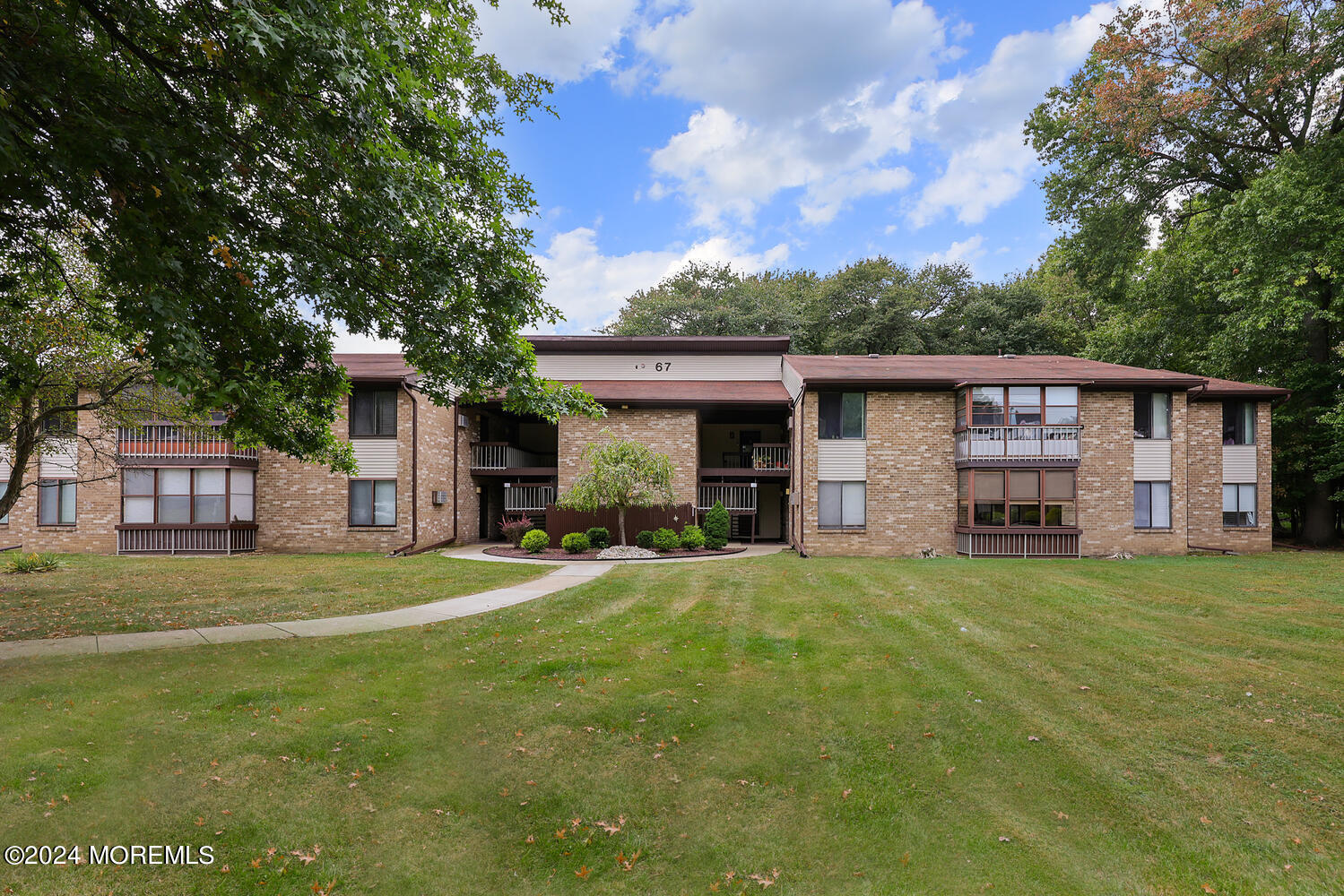a front view of a house with a garden and trees