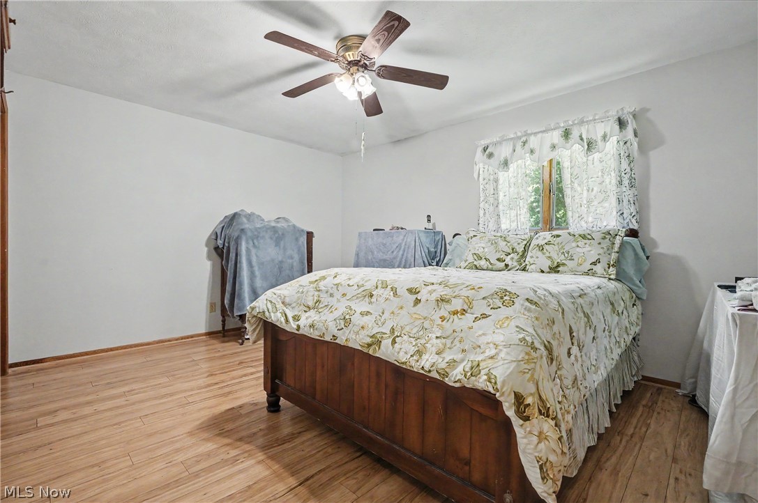 4250 Herr Fieldhouse Road Southington, OH 44470 - Photo 13 of 50 Spacious room featuring wood-finish flooring, white walls, and a ceiling fan with integrated lighting