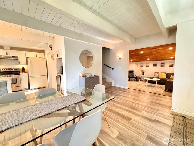 a living room with stainless steel appliances kitchen island granite countertop furniture and a large window