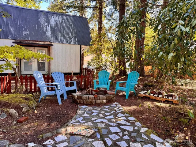 a backyard of a house with barbeque oven table and chairs