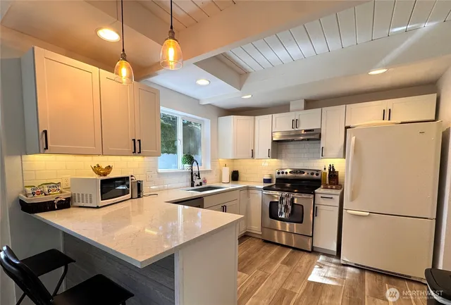 a kitchen with refrigerator cabinets and wooden floor