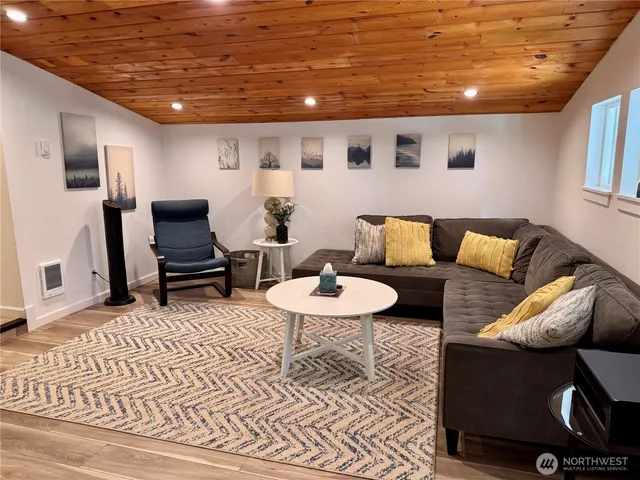 a living room with furniture and a view of kitchen