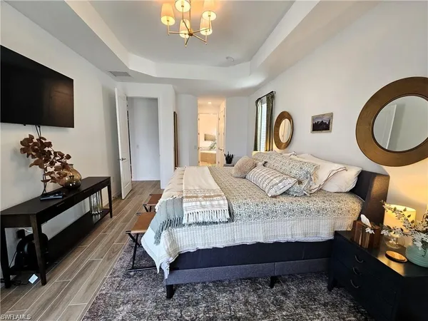 a bedroom with a bed and a flat tv screen on dresser