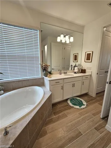 a spacious bathroom with a tub sink and mirror