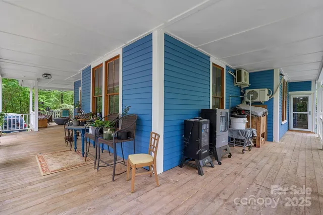 a view of a patio with table and chairs and potted plants with wooden floor
