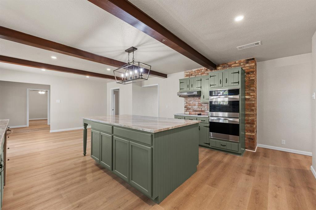 401 Edgewood Lane Cleburne, TX 76031 - Photo 12 of 39 a kitchen with stainless steel appliances granite countertop a sink and stove top oven