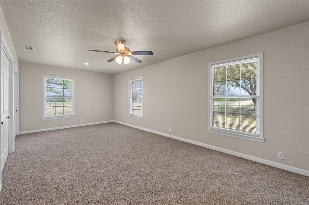 401 Edgewood Lane Cleburne, TX 76031 - Photo 14 of 39 an empty room with windows and fan