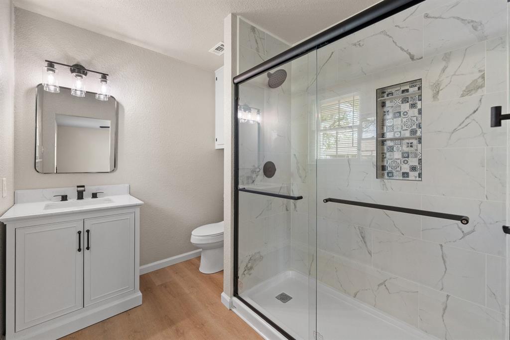 401 Edgewood Lane Cleburne, TX 76031 - Photo 16 of 39 a bathroom with a shower sink mirror and toilet