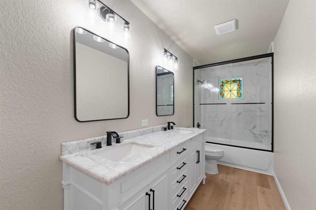 401 Edgewood Lane Cleburne, TX 76031 - Photo 19 of 39 a bathroom with a double vanity sink and a mirror