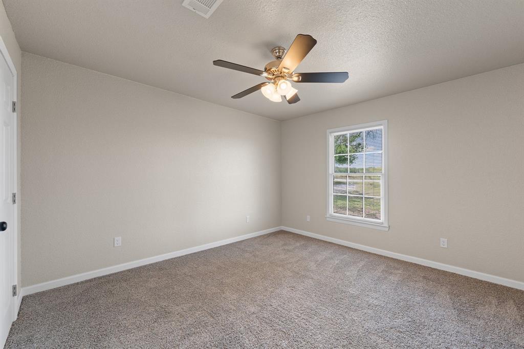 401 Edgewood Lane Cleburne, TX 76031 - Photo 20 of 39 an empty room with windows and fan