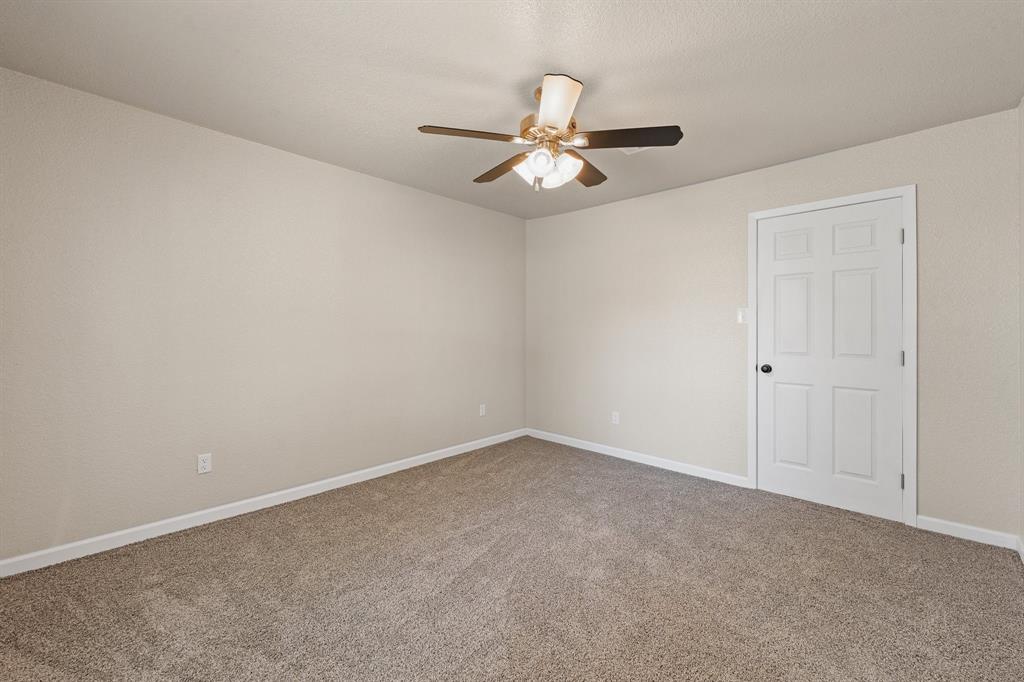 401 Edgewood Lane Cleburne, TX 76031 - Photo 21 of 39 an empty room with a window and a fan
