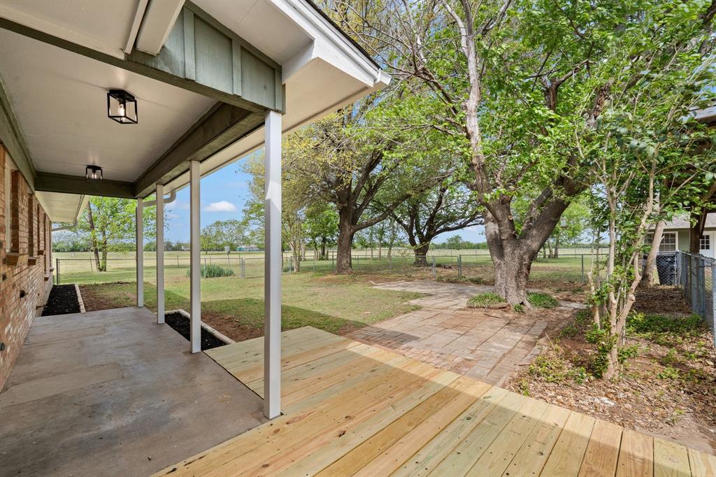 401 Edgewood Lane Cleburne, TX 76031 - Photo 23 of 39 a porch with a table and chairs next to a yard