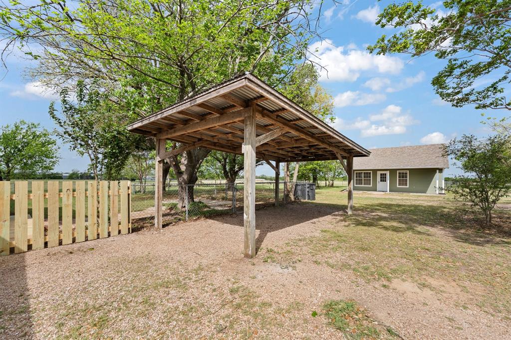 401 Edgewood Lane Cleburne, TX 76031 - Photo 26 of 39 a patio with a table and chairs under an umbrella
