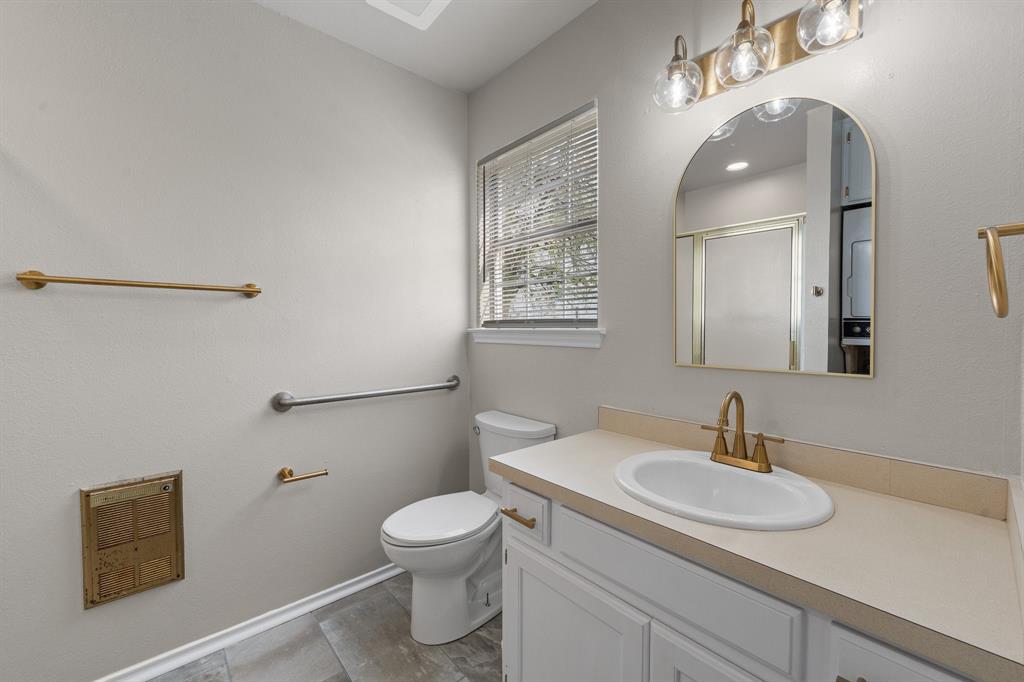 401 Edgewood Lane Cleburne, TX 76031 - Photo 34 of 39 a bathroom with a sink a toilet and mirror