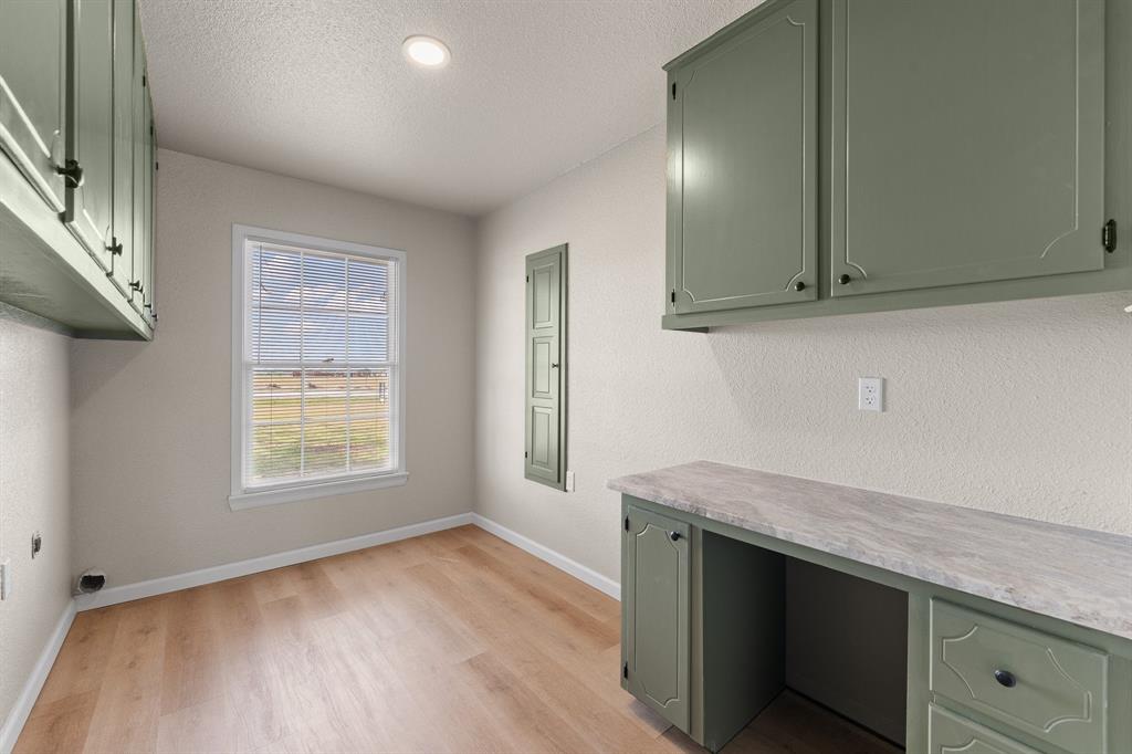 401 Edgewood Lane Cleburne, TX 76031 - Photo 35 of 39 an empty room with wooden floor and cabinet