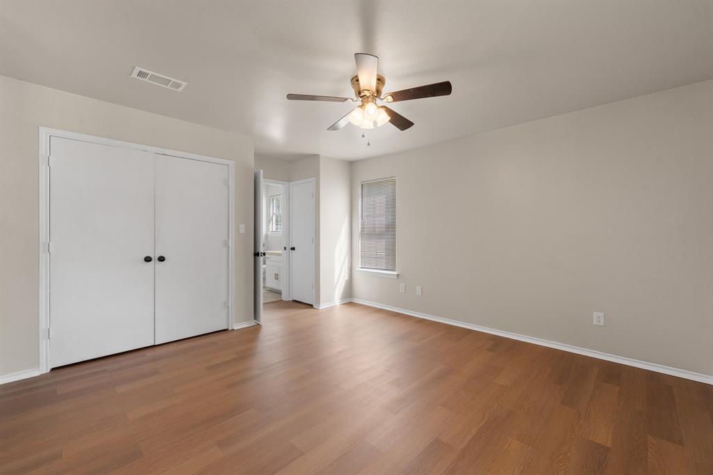 401 Edgewood Lane Cleburne, TX 76031 - Photo 36 of 39 an empty room with wooden floor ceiling fan and windows