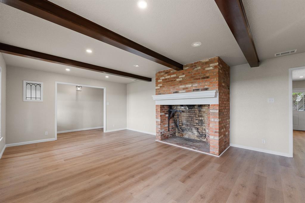 401 Edgewood Lane Cleburne, TX 76031 - Photo 6 of 39 an empty room with wooden floor and a fireplace