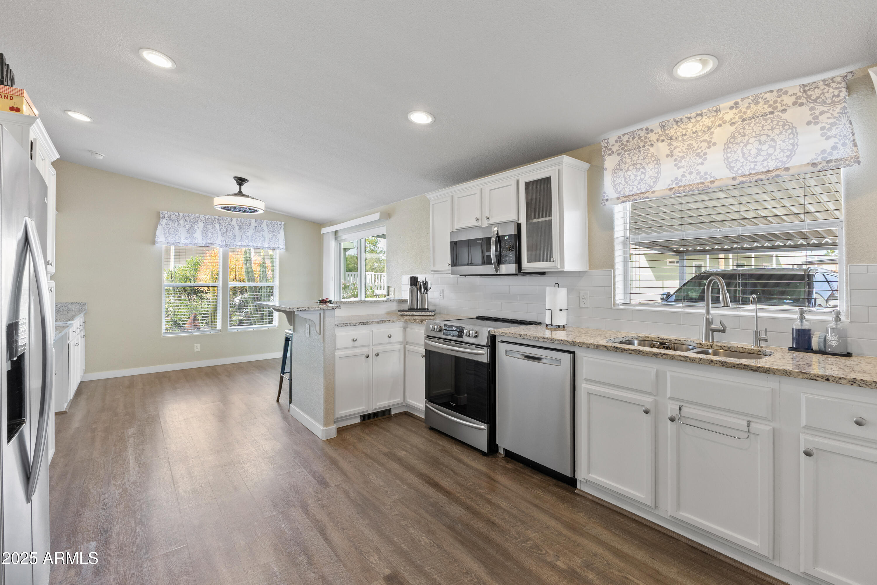 2000 South Apache Road, Unit 156 Buckeye, AZ 85326 - Photo 12 of 40 a kitchen with granite countertop white cabinets and white appliances