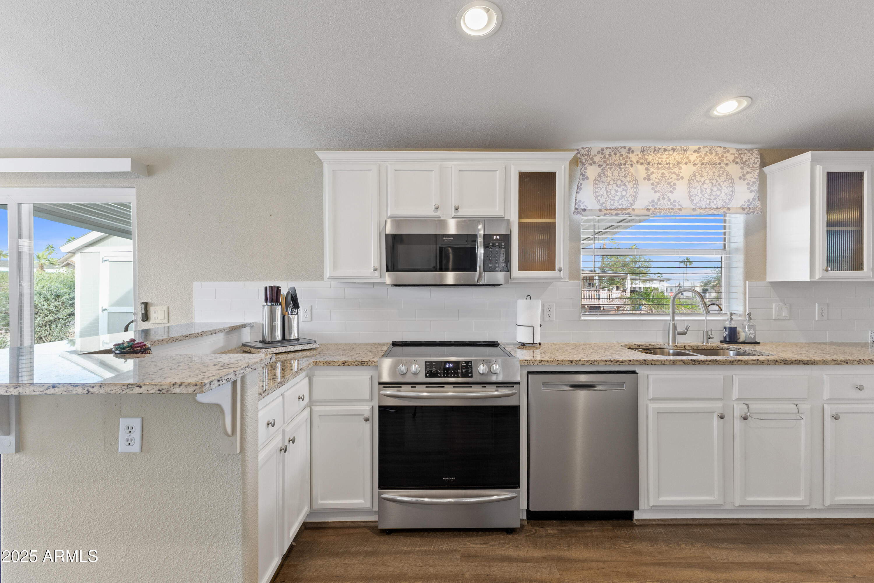 2000 South Apache Road, Unit 156 Buckeye, AZ 85326 - Photo 18 of 40 a kitchen with stainless steel appliances granite countertop a sink and stove top oven