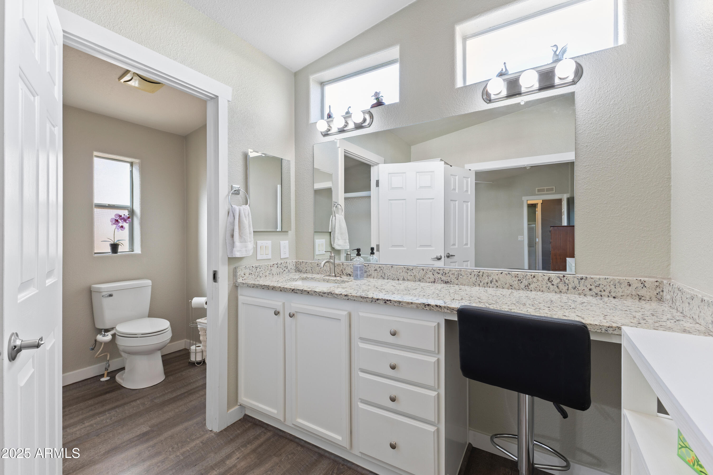 2000 South Apache Road, Unit 156 Buckeye, AZ 85326 - Photo 26 of 40 a bathroom with a granite countertop sink a toilet and a mirror