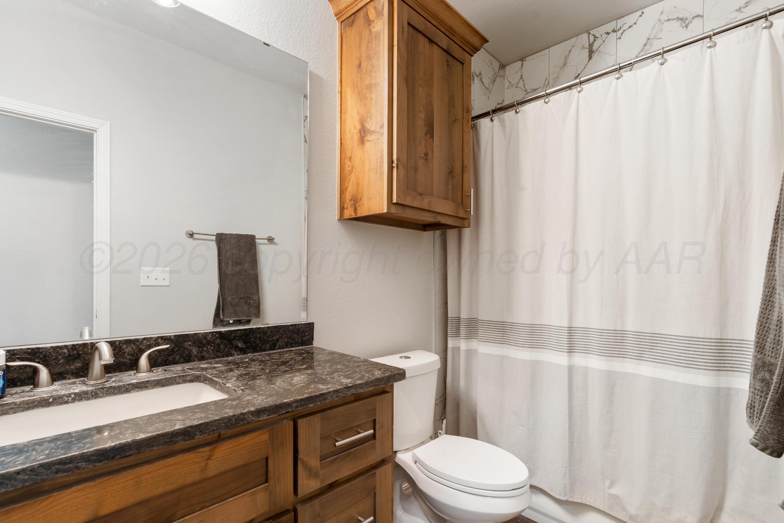 151 North Fm 2381 Amarillo, TX 79124 - Photo 21 of 36 a bathroom with a granite countertop sink a toilet and a mirror