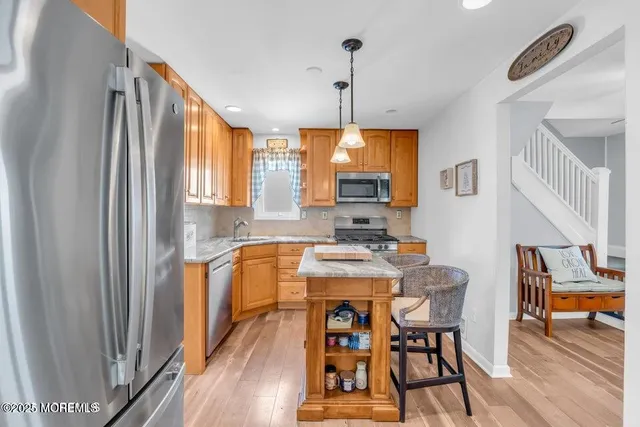 a kitchen with stainless steel appliances granite countertop furniture wooden floor and a window