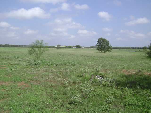 1450 Acorn Road Luling, TX 78648 - Photo 1 of 1 a view of a big yard with a house in the background