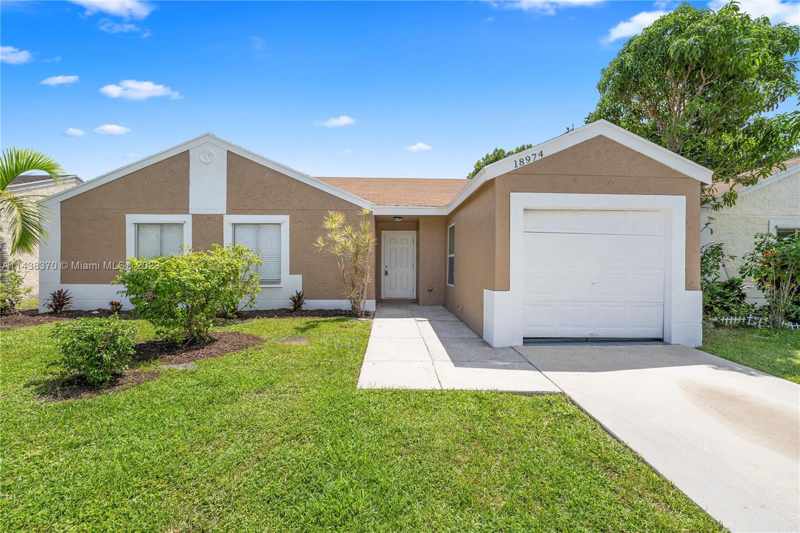 a front view of a house with yard and garage