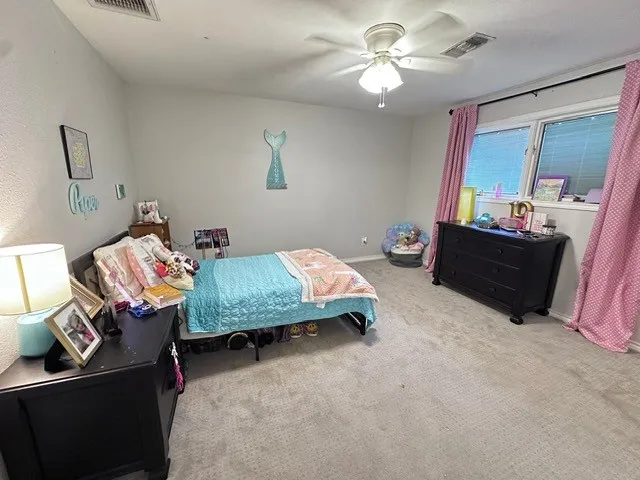 a spacious bedroom with a bed and a chandelier