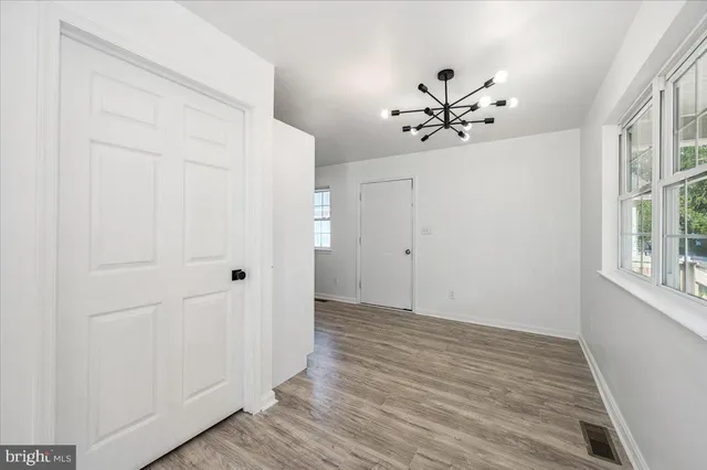an empty room with a window and a ceiling fan