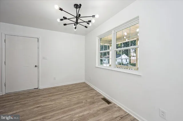 a kitchen with wooden floors white cabinets and stainless steel appliances