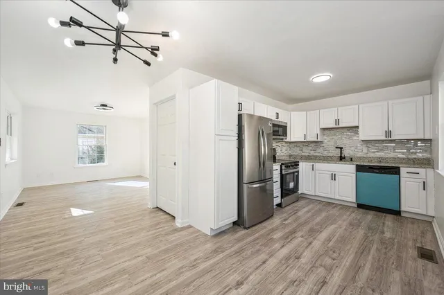 a kitchen with stainless steel appliances granite countertop a stove and a microwave
