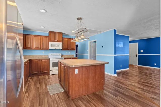 a kitchen that has a lot of cabinets in it and wooden floor