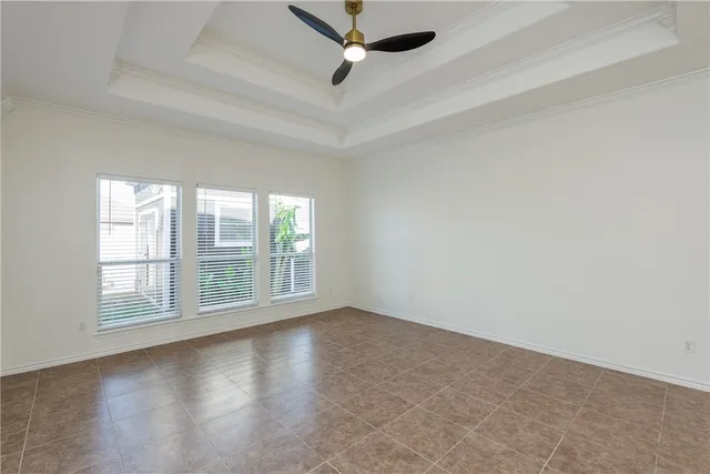 an empty room with windows and ceiling fan