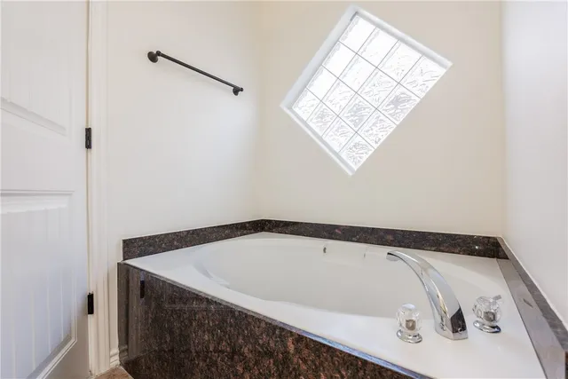 a bathroom with a bathtub and a window