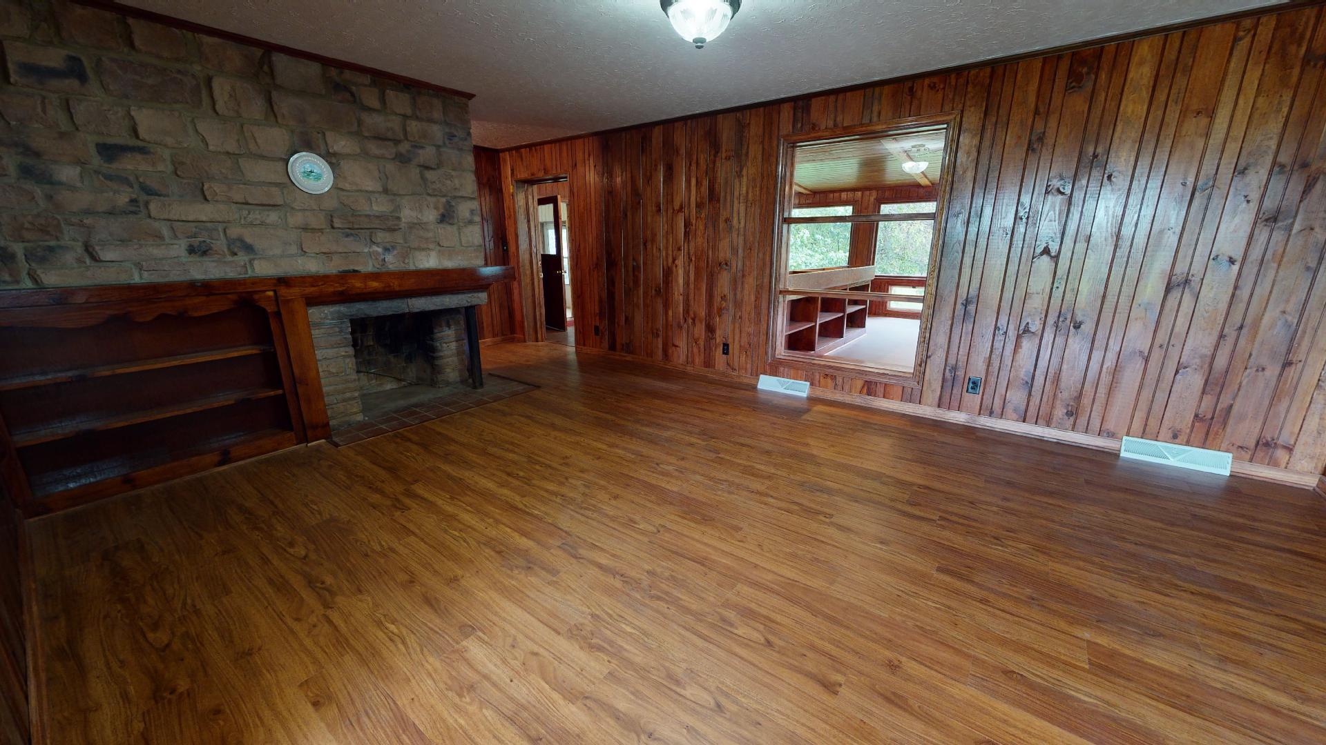 420 Long Level Road Southwest Floyd, VA 24091 - Photo 6 of 15 an empty room with wooden floor fireplace and windows