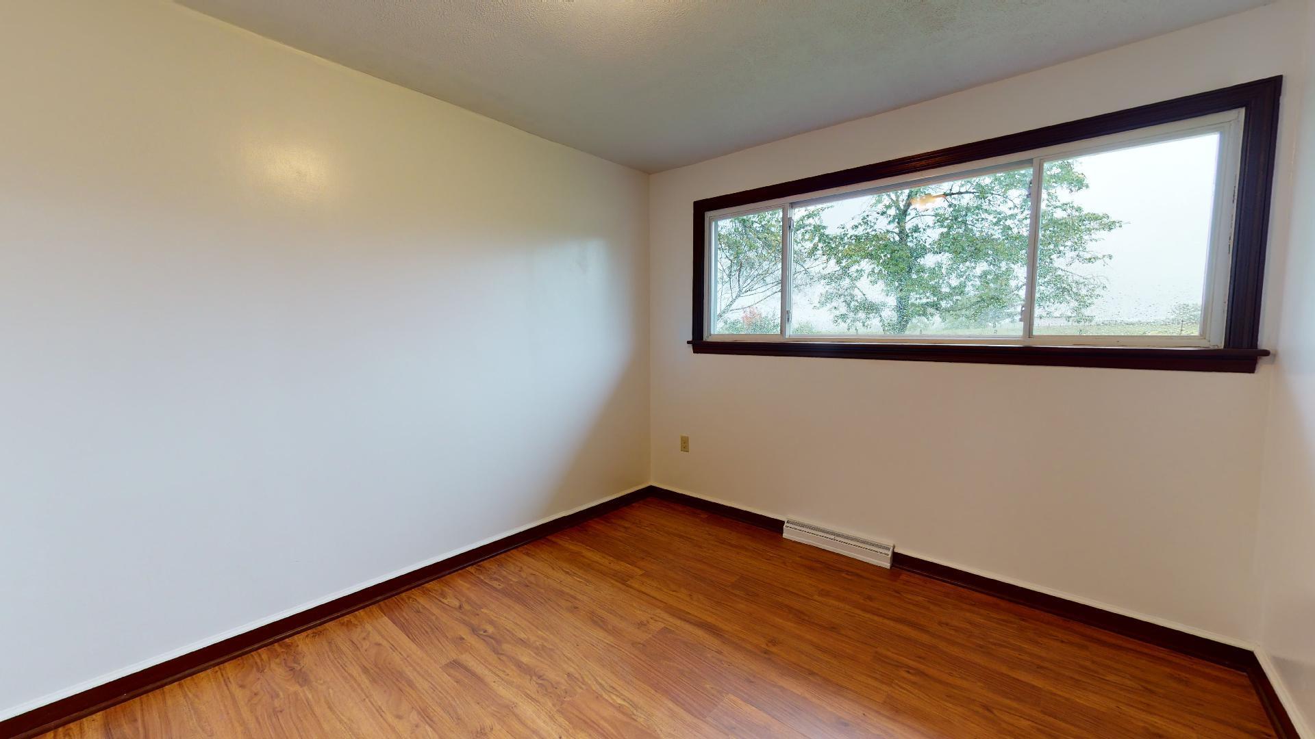 420 Long Level Road Southwest Floyd, VA 24091 - Photo 7 of 15 an empty room with wooden floor and windows