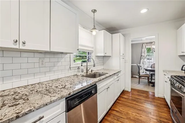 a kitchen with granite countertop a sink stove and cabinets