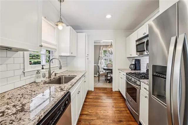 a kitchen with stainless steel appliances granite countertop a sink stove and refrigerator