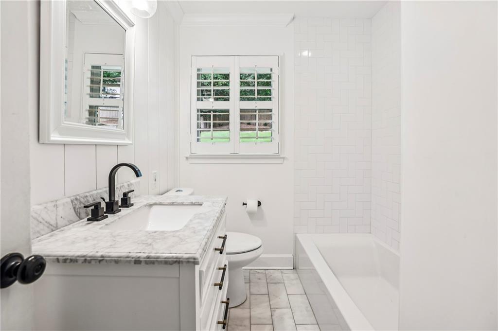 2226 Fairway Circle Northeast Brookhaven, GA 30319 - Photo 19 of 26 a bathroom with a granite countertop sink a toilet and a bathtub